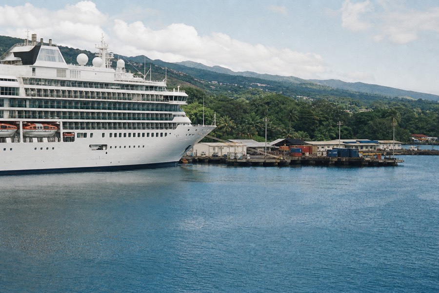 A cruise ship berthed in Hilo Bay below the green volcanic hills
